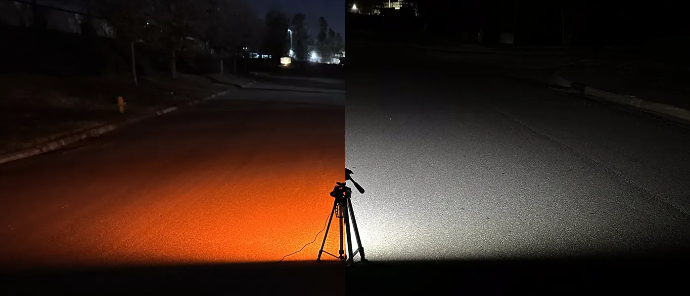 A Diamond Duo light at night on a tripod, its amber channel lighting the road on the left and its white channel on the right